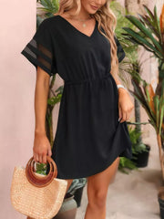 Black V-neck mini dress with sheer striped sleeves and an elastic waist.