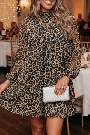 Chic leopard print tiered shift dress with mock neck and long sleeves.