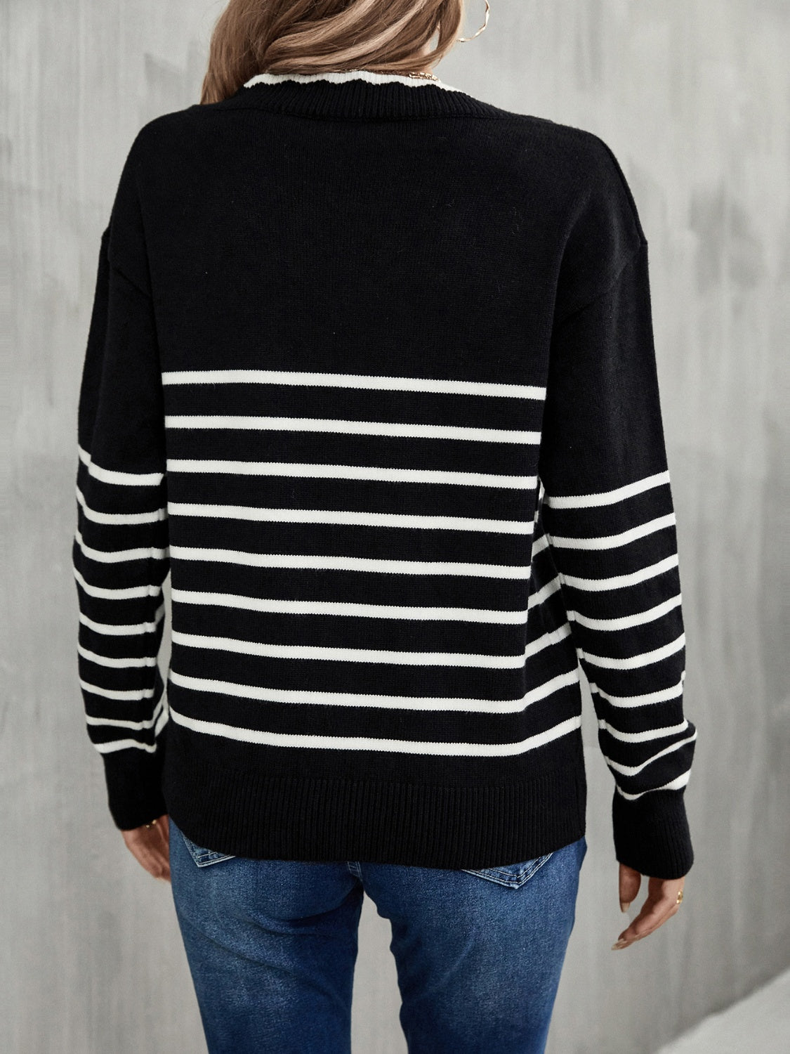 Black and white striped knit sweater with scalloped trim neckline and ribbed cuffs.