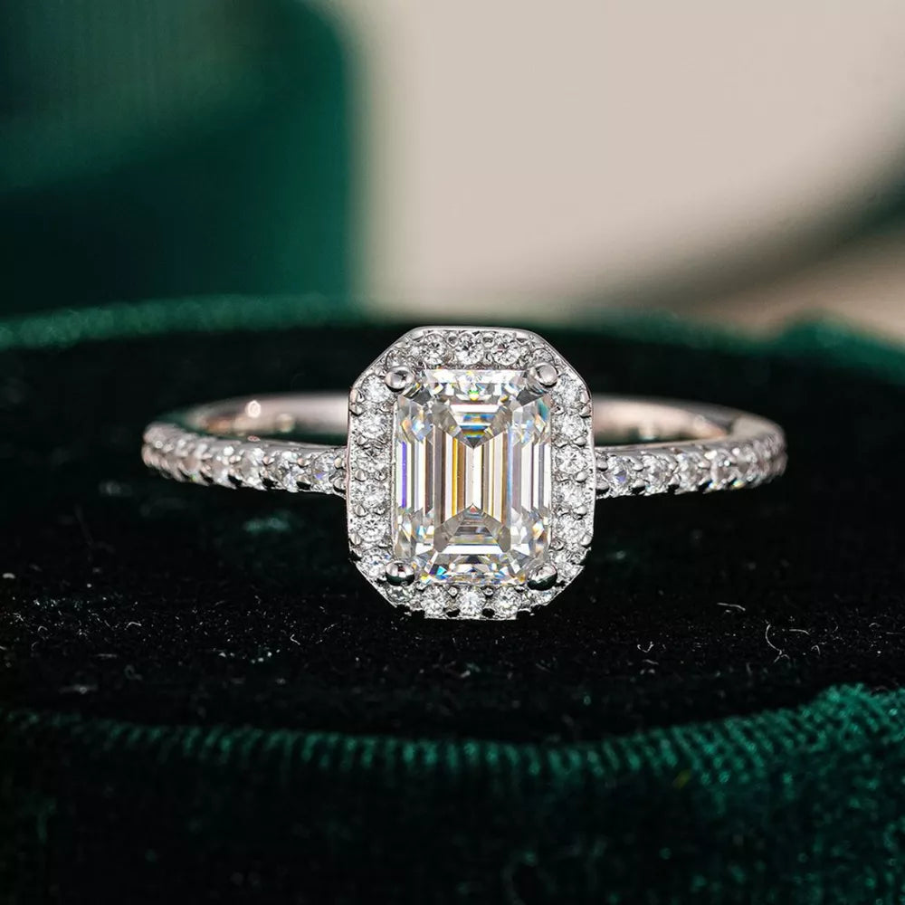 Radiant moissanite engagement ring in silver with a halo of small diamonds.