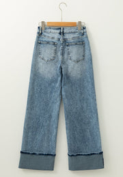 Medium washed denim jeans with cuffed hems and a wide leg.