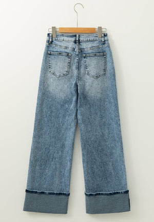 Medium washed denim jeans with cuffed hems and a wide leg.