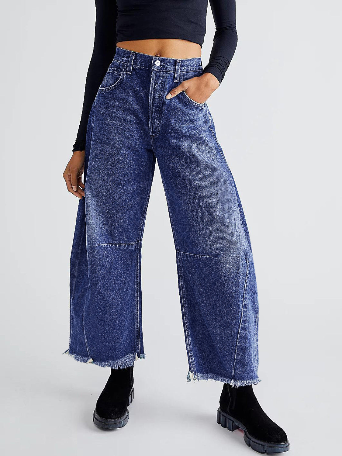 Frayed hemline palazzo jeans in medium wash denim with a wide leg and raw hem.