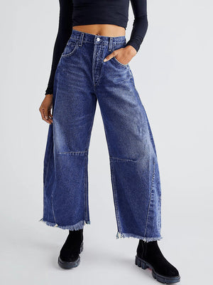 Frayed hemline palazzo jeans in medium wash denim with a wide leg and raw hem.