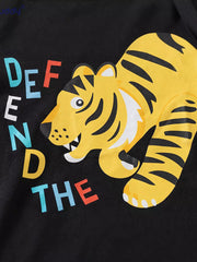 Black cotton baby tee with a yellow tiger graphic and colorful text.