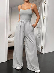 Grey wide-leg maternity romper with spaghetti straps and pockets, perfect for casual chic style.