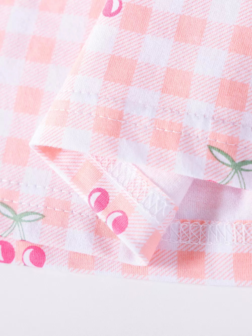 Baby dress with pink gingham and cherry embroidery.