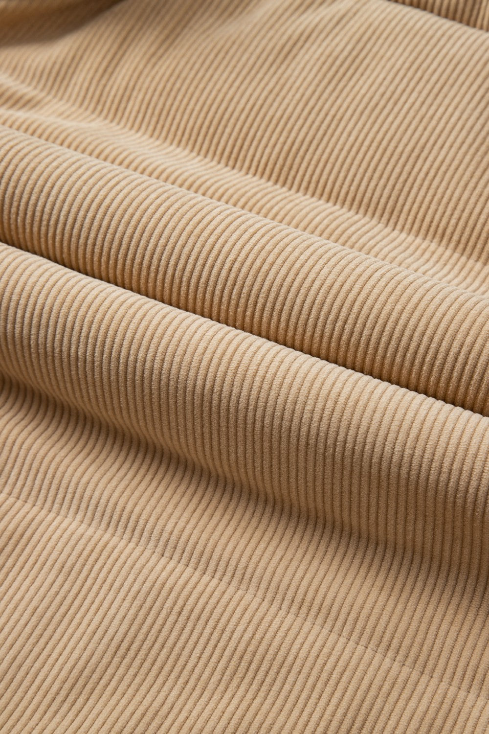 Tan corduroy padded vest fabric detail with soft texture and vertical wales.