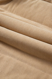 Tan corduroy padded vest fabric detail with soft texture and vertical wales.