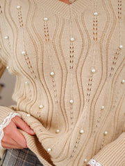 Beige V-neck knit sweater with pearl details and lace cuffs.