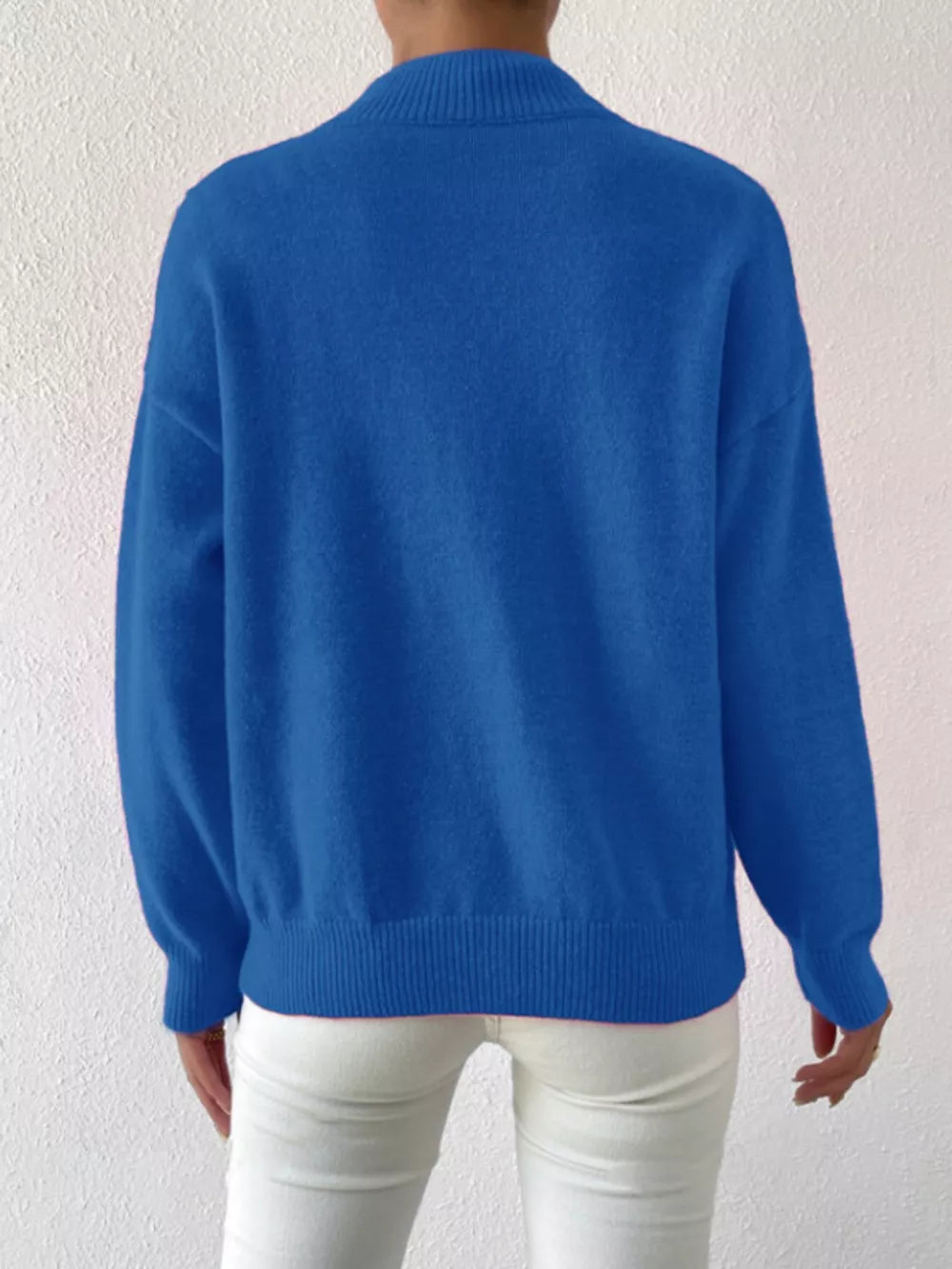 Blue mock neck knit sweater with dropped shoulders and ribbed cuffs and hem.