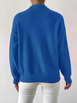 Blue mock neck knit sweater with dropped shoulders and ribbed cuffs and hem.