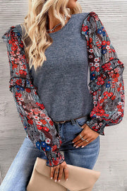 Gray knit top with sheer floral print balloon sleeves and ruffled cuffs.