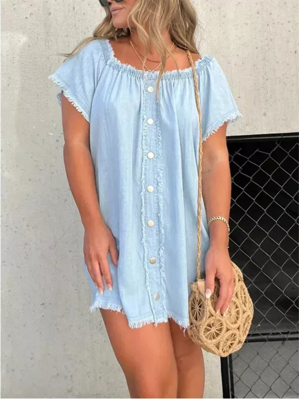 Light blue frayed hem off-shoulder denim dress with button front and short sleeves.