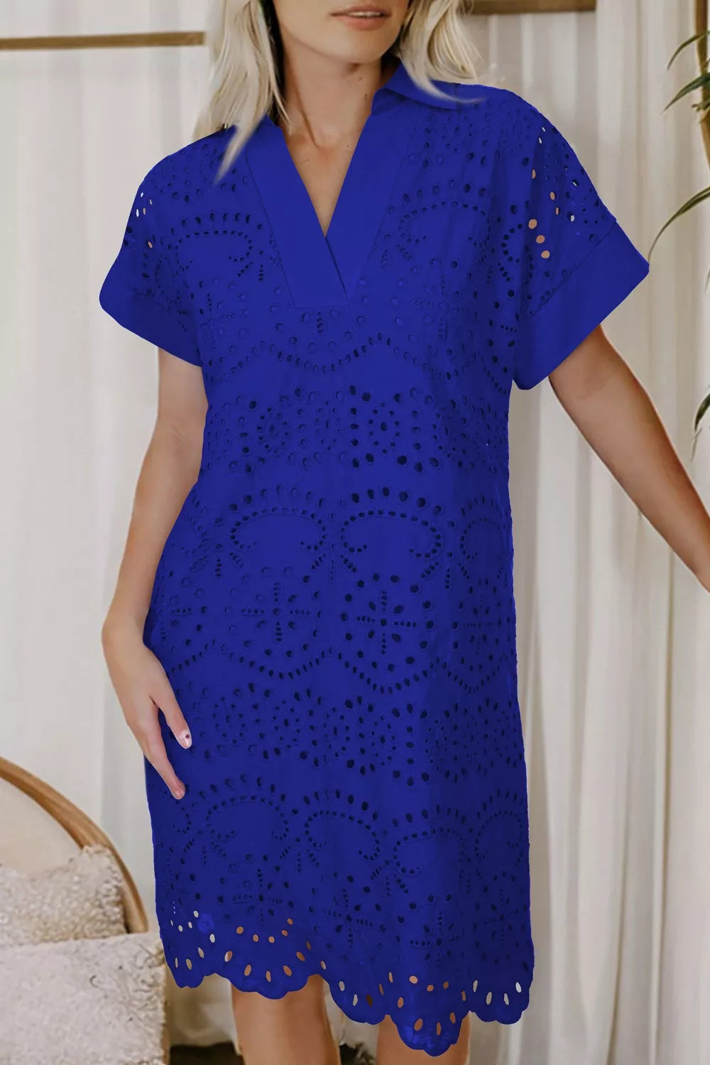 Blue cotton eyelet mini dress with V-neck, short sleeves, and scalloped hem.