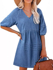 Light blue denim mini dress with puff sleeves, V-neck, tiered skirt and smocked waist.