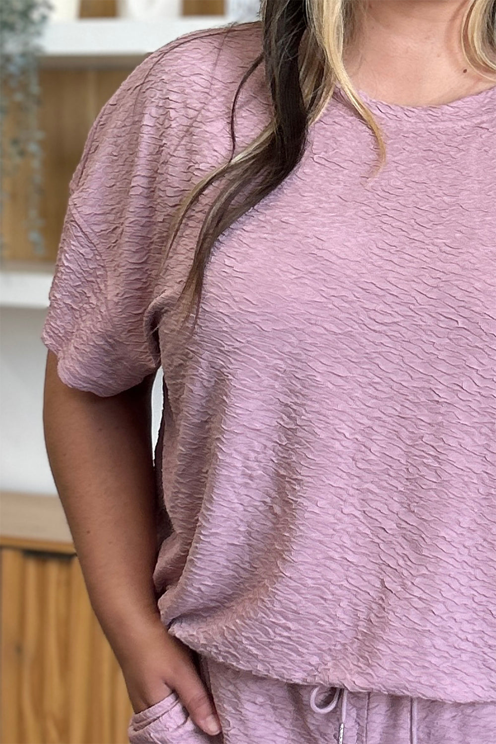 Textured cocoon top in dusty pink with short sleeves and matching wide leg pants.