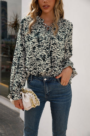 Animal print blouse with ruffle neckline and tie detail, long sleeves, and ruffled cuffs.