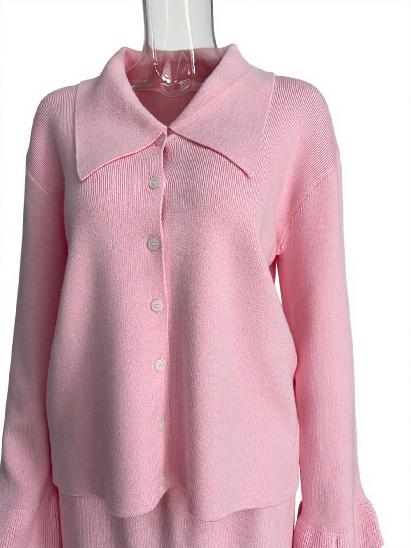 Pink ribbed knit cardigan with collar and button-down front, paired with matching skirt.