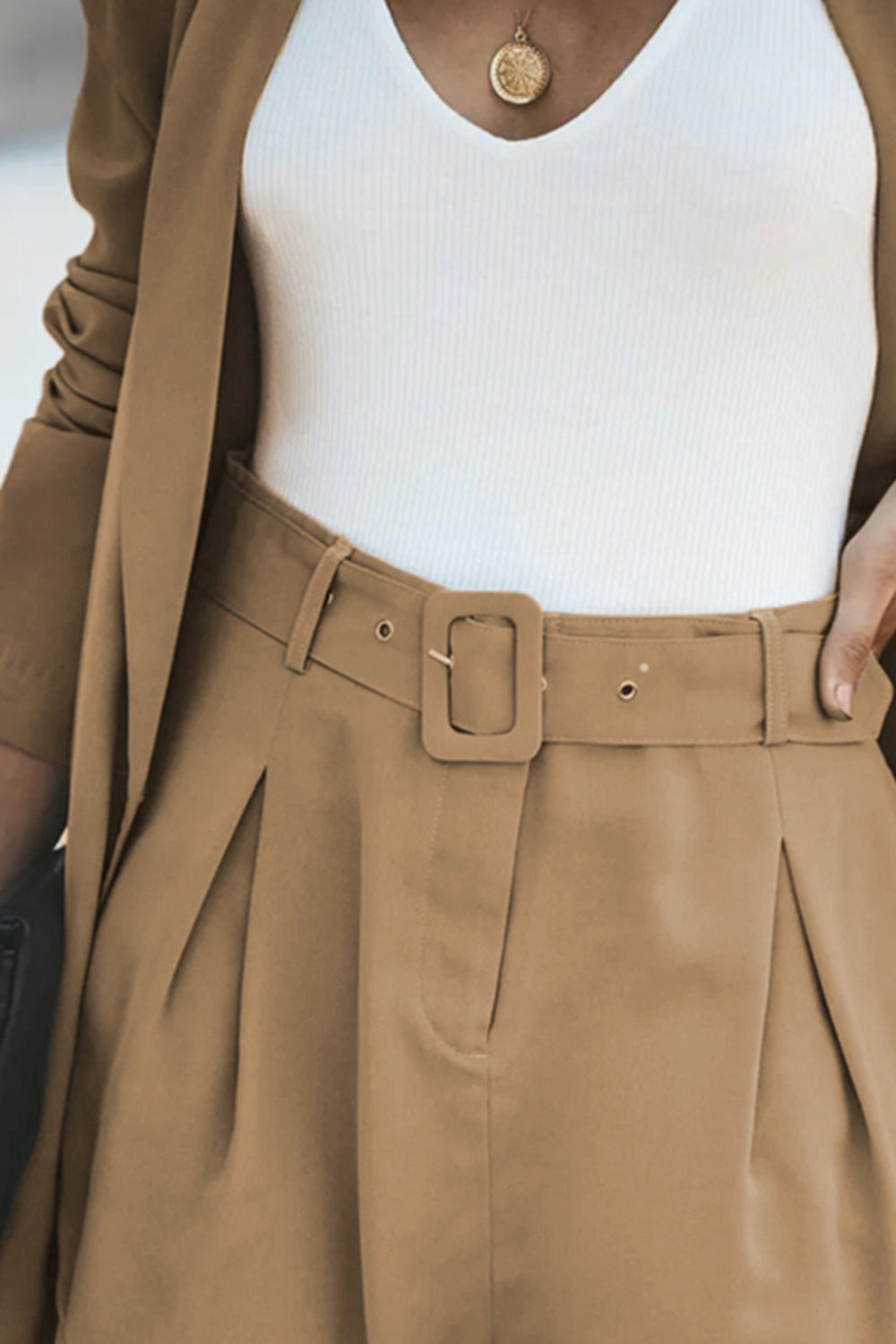 Camel double-breasted blazer and pleated shorts set with a matching belt and white tank top.
