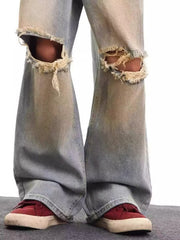 Men's light blue distressed wide leg jeans with frayed knee rips.