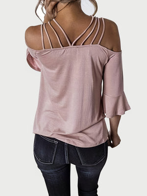 Blush pink blouson top with strappy shoulders and flared sleeves.