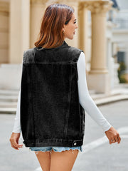 Black oversized denim vest with utility pockets and button closure, styled with a white long-sleeve shirt.