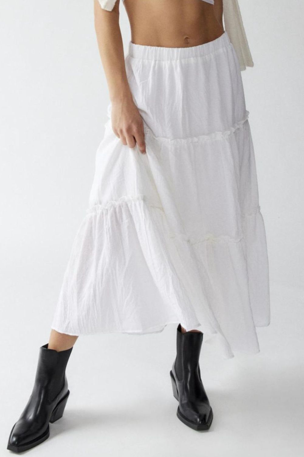 Tiered cotton maxi skirt in white with ruffled tiers and an elastic waistband.