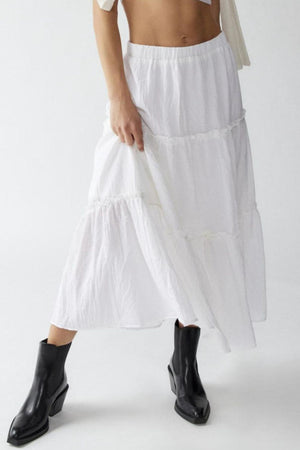 Tiered cotton maxi skirt in white with ruffled tiers and an elastic waistband.