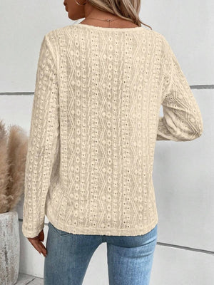 Textured long sleeve henley top in cream with open knit pattern.
