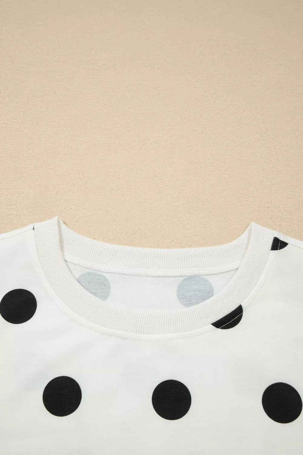 White polka dot two-piece set with ribbed trim neckline and cuffs.