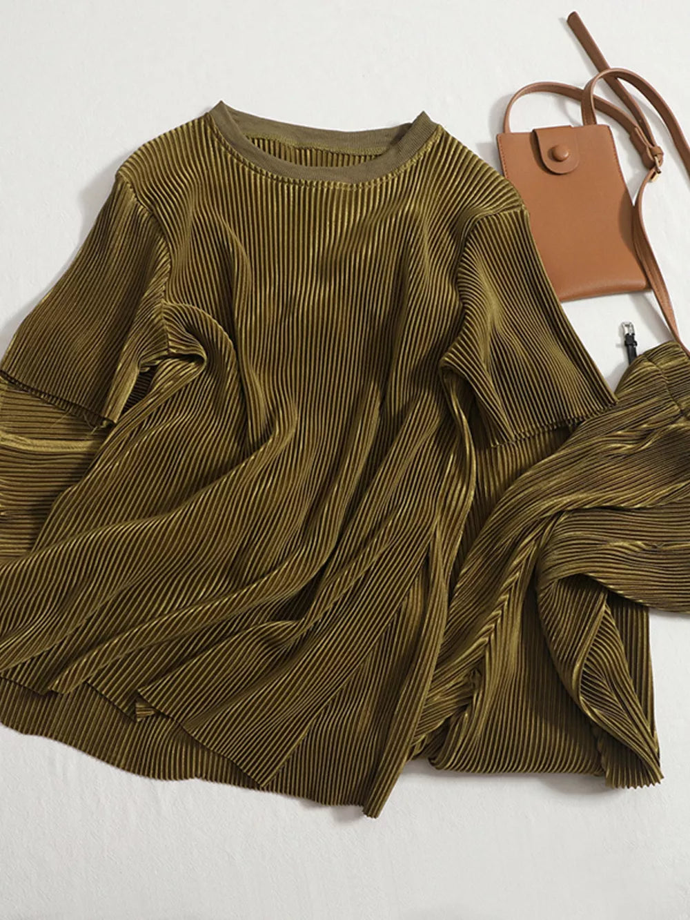 Olive green pleated two-piece set with a round neck top and wide-leg pants.
