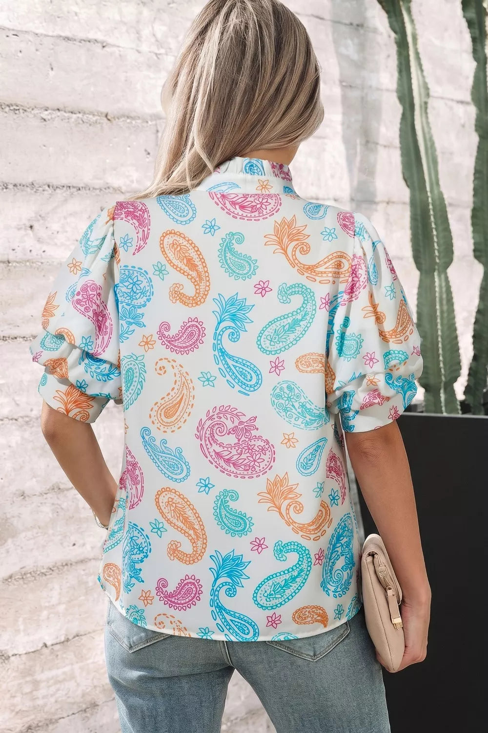 Maternity blouse with puff sleeves and vibrant paisley print in white, pink, blue, and orange.
