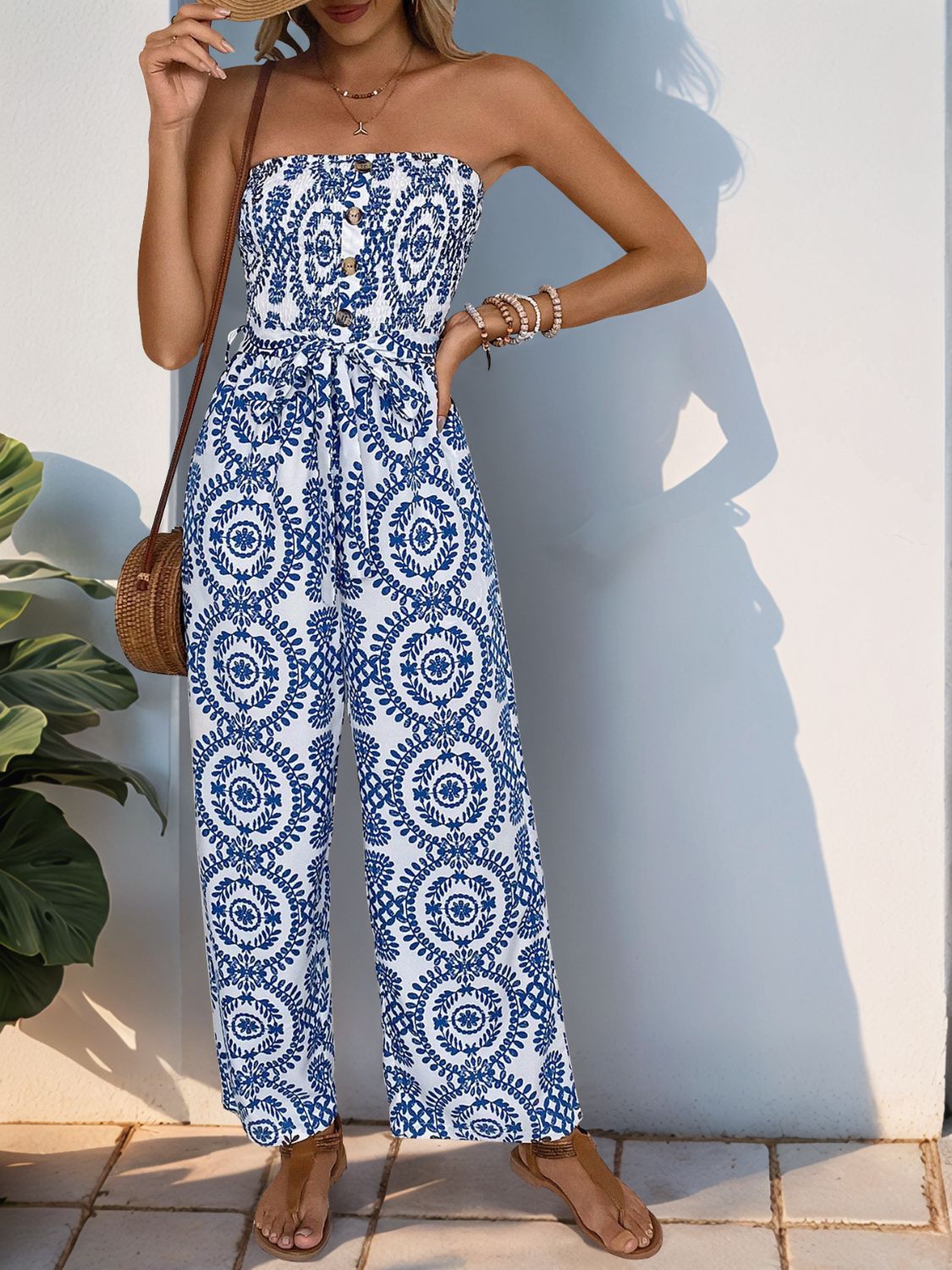 Bustier print wide leg jumpsuit in blue with decorative buttons and tie waist.