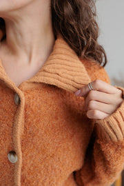 Textured bouclé collar cardigan in tangerine with button front and ribbed collar detail.
