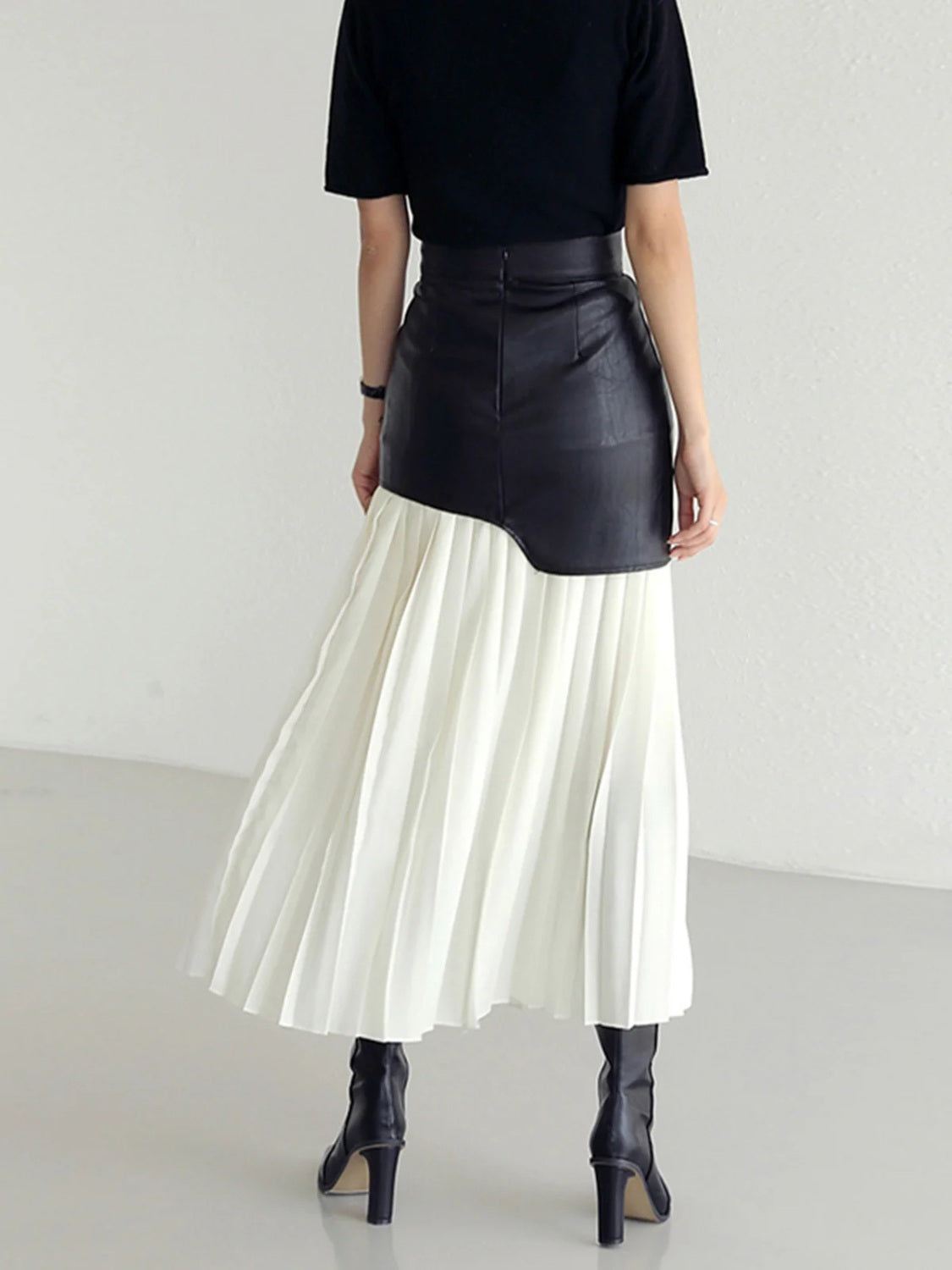 Black leather asymmetric midi skirt with white pleated fabric detail