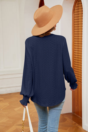 Navy eyelet detail blouse with poet sleeves and ruffled cuffs.