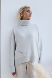 Oversized cashmere turtleneck sweater in light gray with ribbed cuffs and hem.