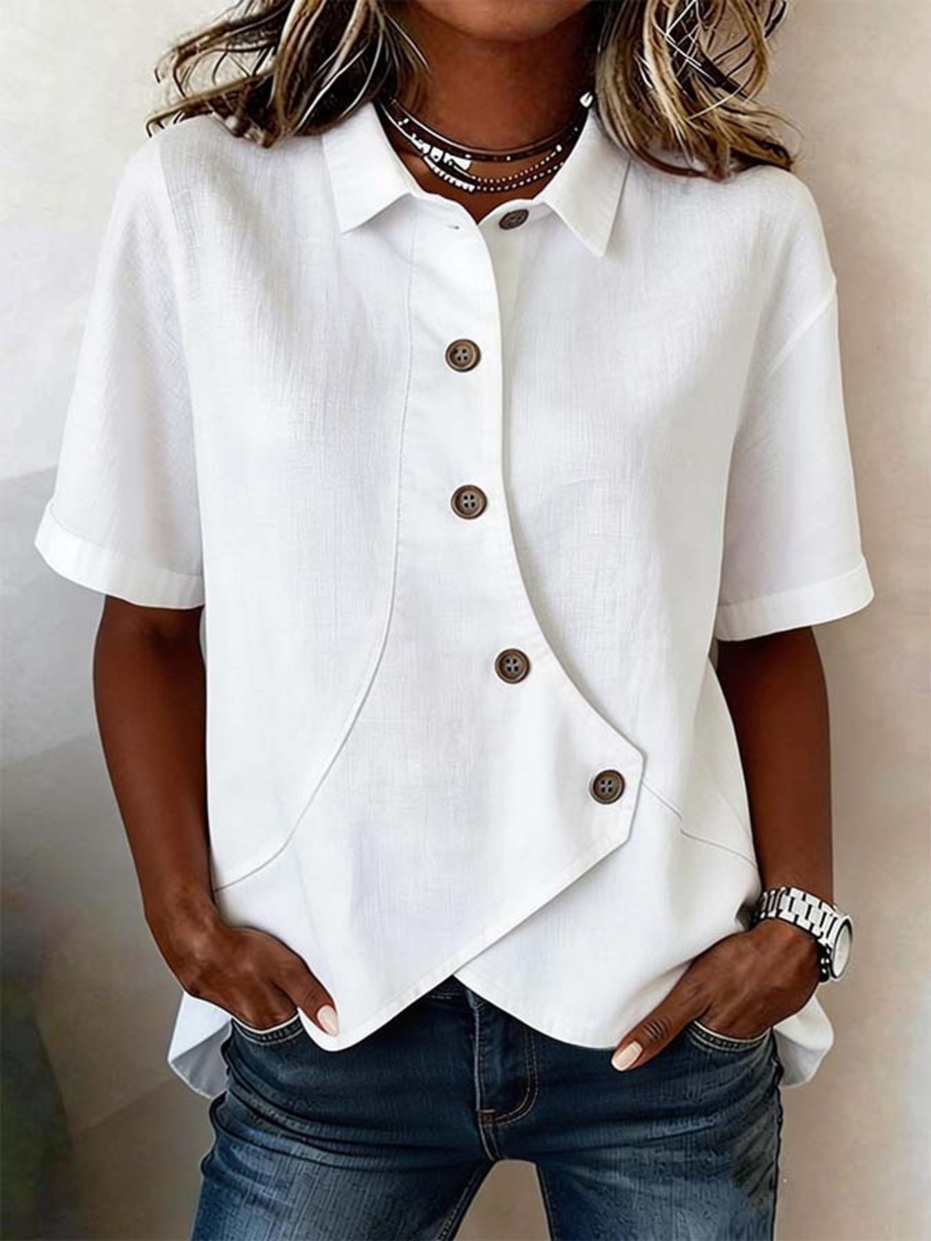White asymmetrical button front shirt with short sleeves and a diagonal placket.