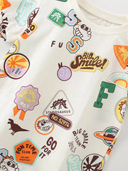 Toddler beige cotton t-shirt with dinosaur and fun graphic patches.