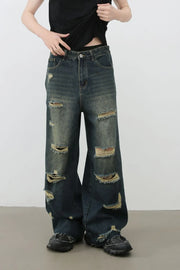 Distressed dark wide leg denim jeans with ripped details and side slits.