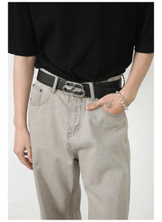 Gray wide-leg denim trousers with seam detail and a silver buckle belt.