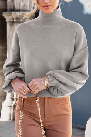 Gray mock neck knit sweater with balloon sleeves and ribbed cuffs.