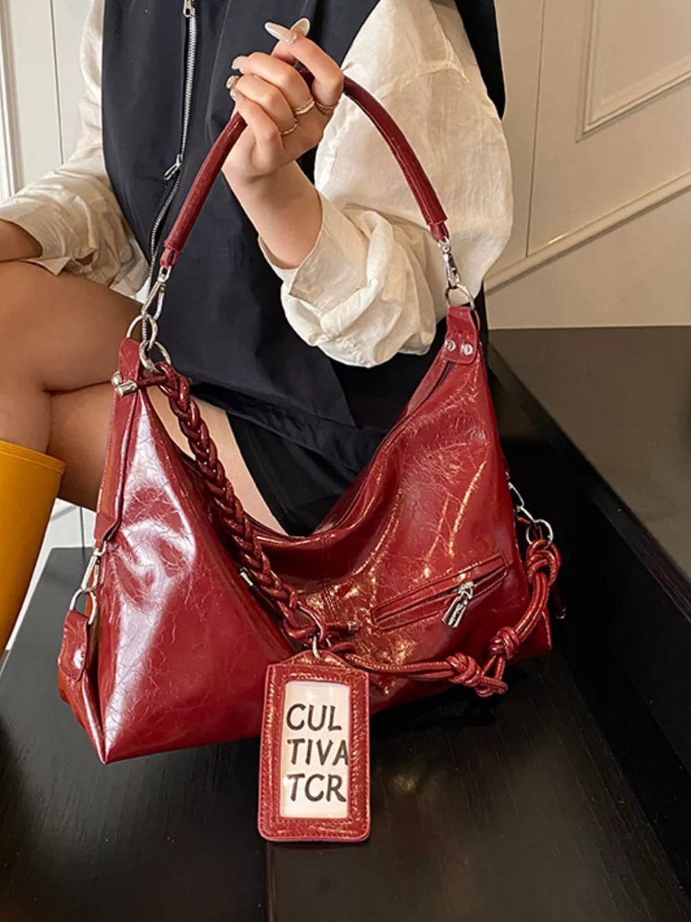 Red shoulder bag with braided strap and vintage-inspired details
