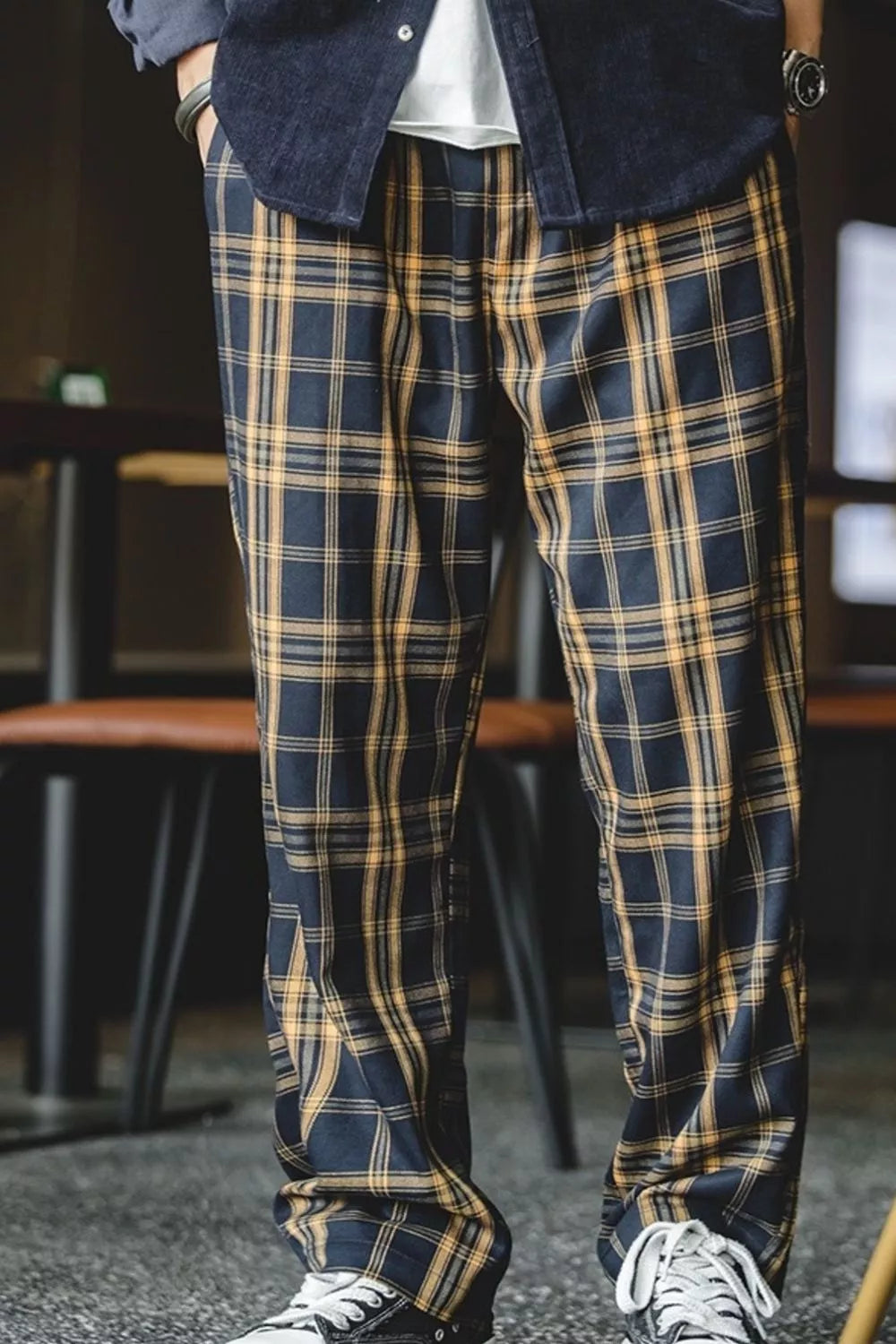 Men's relaxed fit sweatpants in black and mustard plaid with elastic waist.
