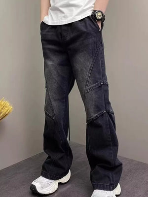 Black distressed wide-leg jeans for men with unique paneling and silver stud details.