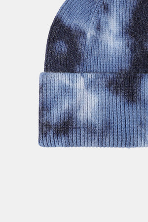 Ribbed knit beanie in blue and black tie-dye pattern with a cuffed hem.
