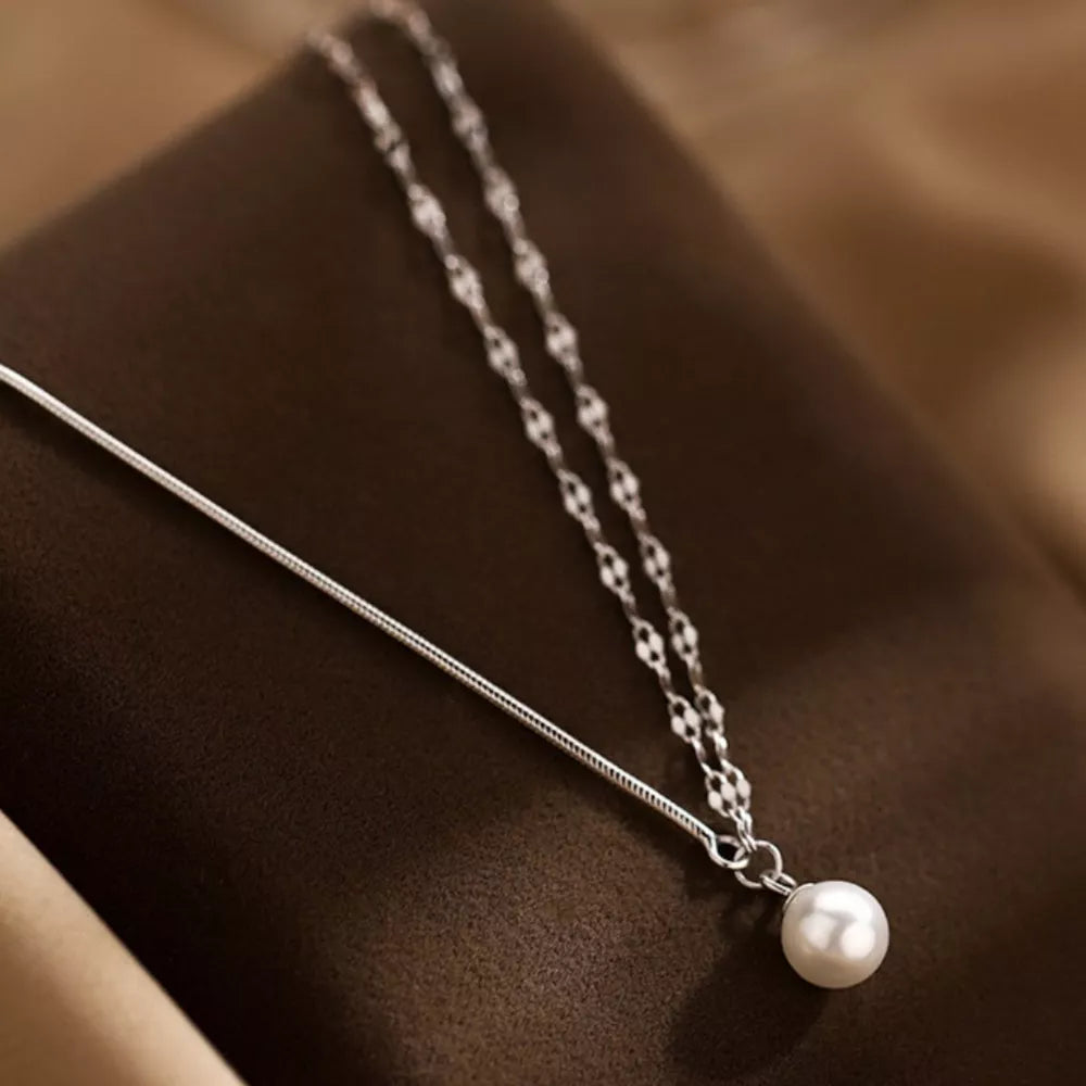 Lustrous pearl pendant layered necklace in 925 sterling silver with delicate chain detail.