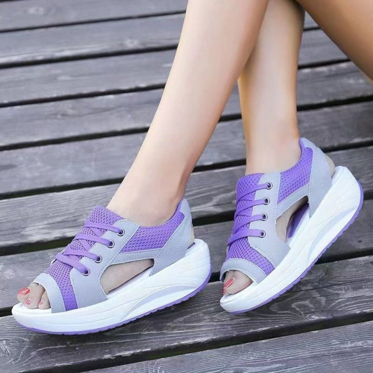 Purple lace-up wedge sandals with breathable mesh and cutouts.