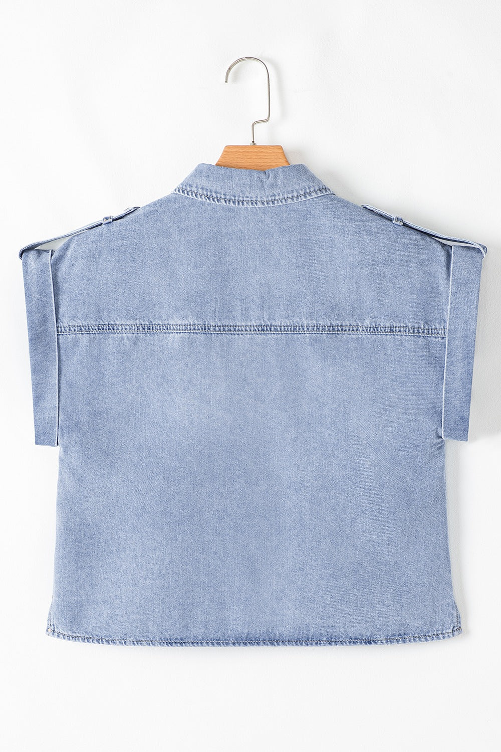 Light blue denim shirt jacket with rolled sleeves and shoulder epaulets.